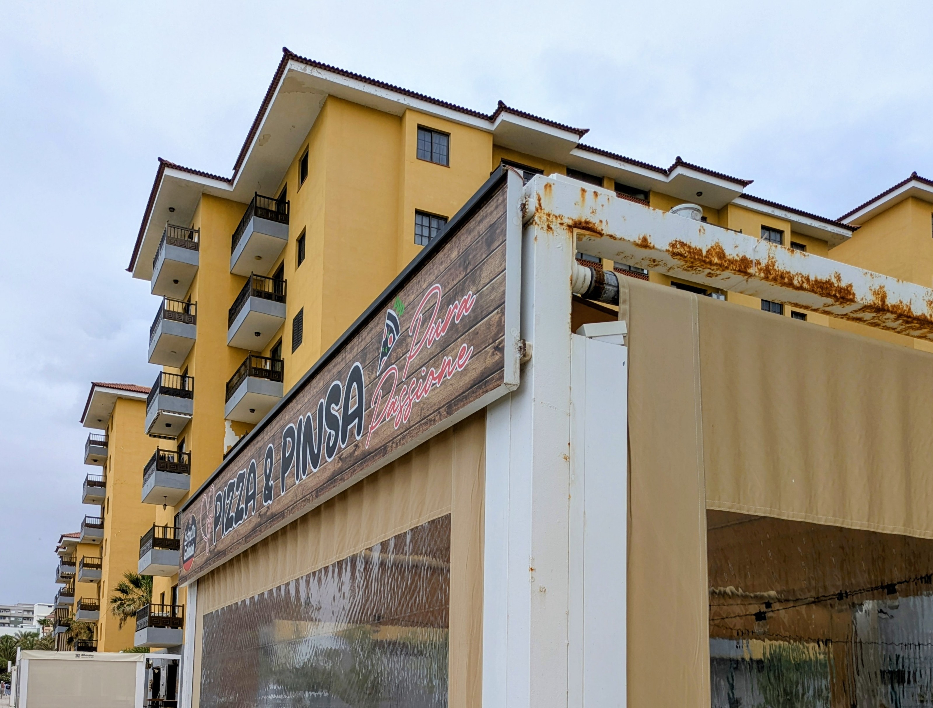 La terraza acristalada con el rótulo Pizza & Pinsa Pura Passione en la Avenida Marítima